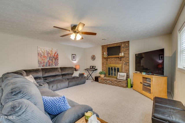 carpeted living room featuring a brick fireplace, a ceiling fan, and a textured ceiling