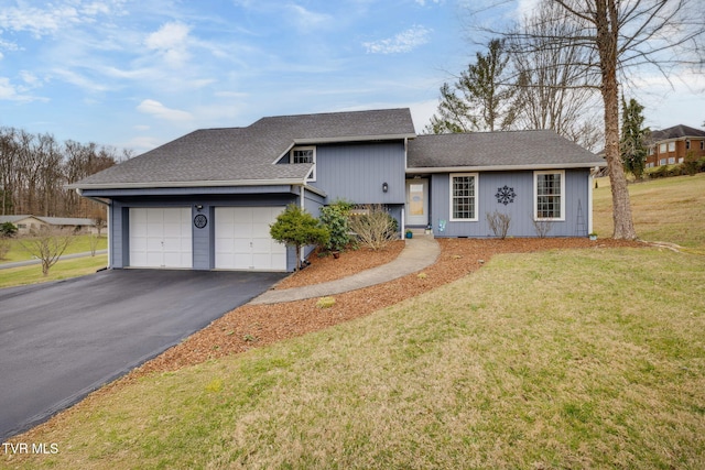 split level home with driveway, a shingled roof, a garage, and a front lawn