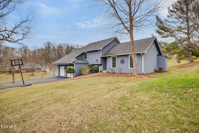 view of front of house featuring driveway, a shingled roof, an attached garage, central air condition unit, and a front lawn