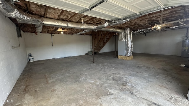 unfinished basement featuring concrete block wall and water heater