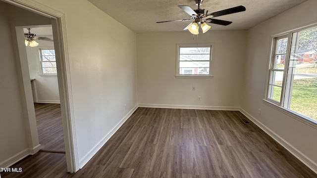 unfurnished room featuring dark wood-style floors, a textured ceiling, and a wealth of natural light