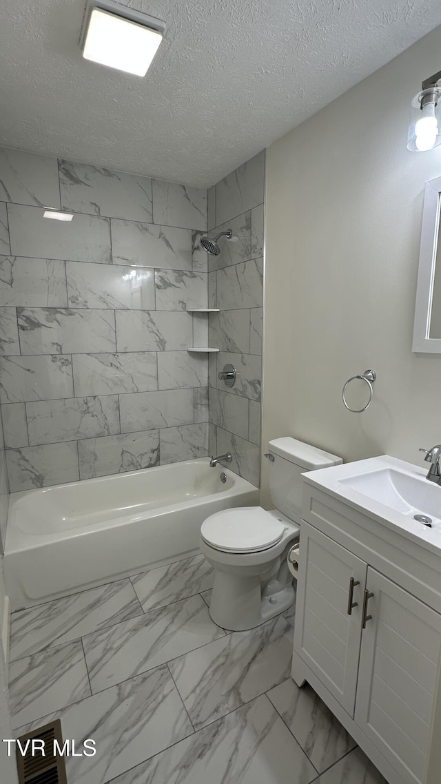 full bathroom with a textured ceiling, toilet, vanity, marble finish floor, and shower / washtub combination