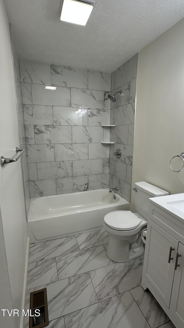 bathroom with marble finish floor, bathing tub / shower combination, toilet, a textured ceiling, and vanity