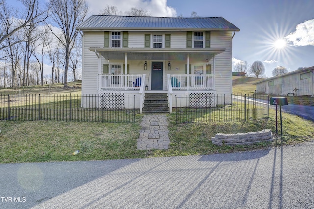 view of front of property with metal roof, a porch, a front lawn, and a fenced front yard