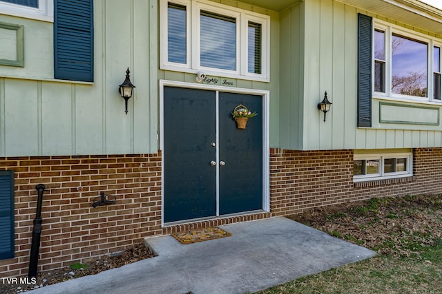 entrance to property featuring brick siding and board and batten siding