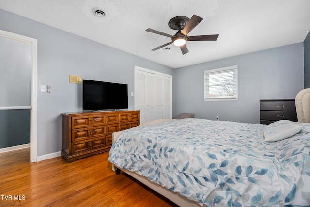 bedroom featuring a ceiling fan, baseboards, visible vents, a closet, and light wood-type flooring