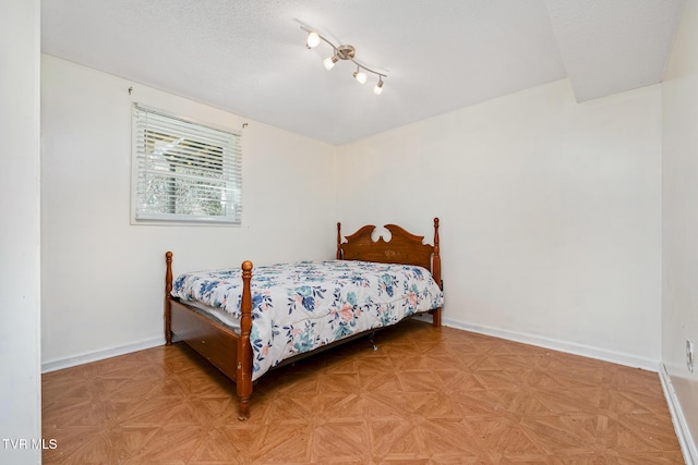 bedroom with baseboards and a textured ceiling