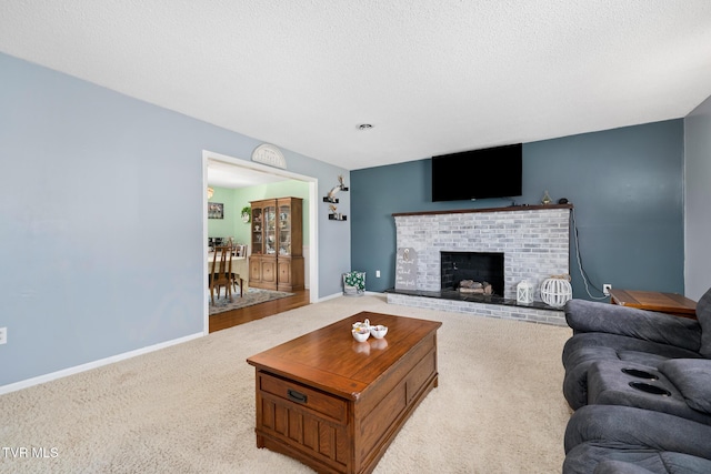 living room featuring carpet flooring, a brick fireplace, a textured ceiling, and baseboards