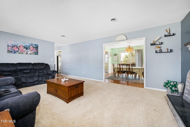 carpeted living room with visible vents, a textured ceiling, and baseboards