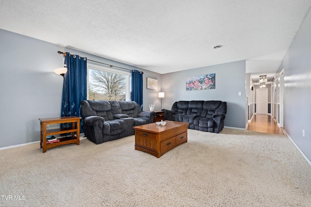 living area with carpet, baseboards, and a textured ceiling