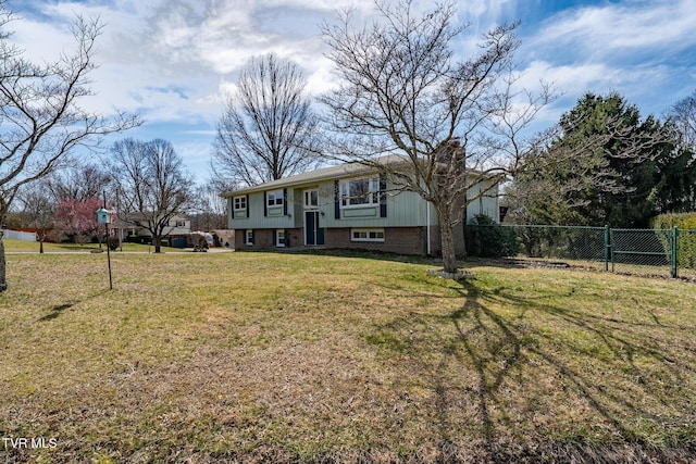 view of front of property with brick siding, a chimney, a front lawn, and fence