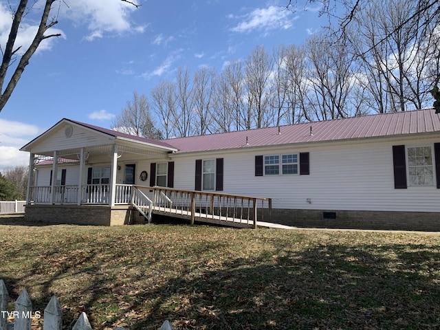 view of front facade with a front yard, metal roof, covered porch, and crawl space