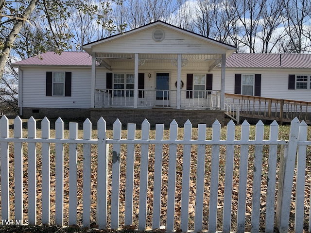 view of front of house with crawl space, covered porch, a fenced front yard, and metal roof