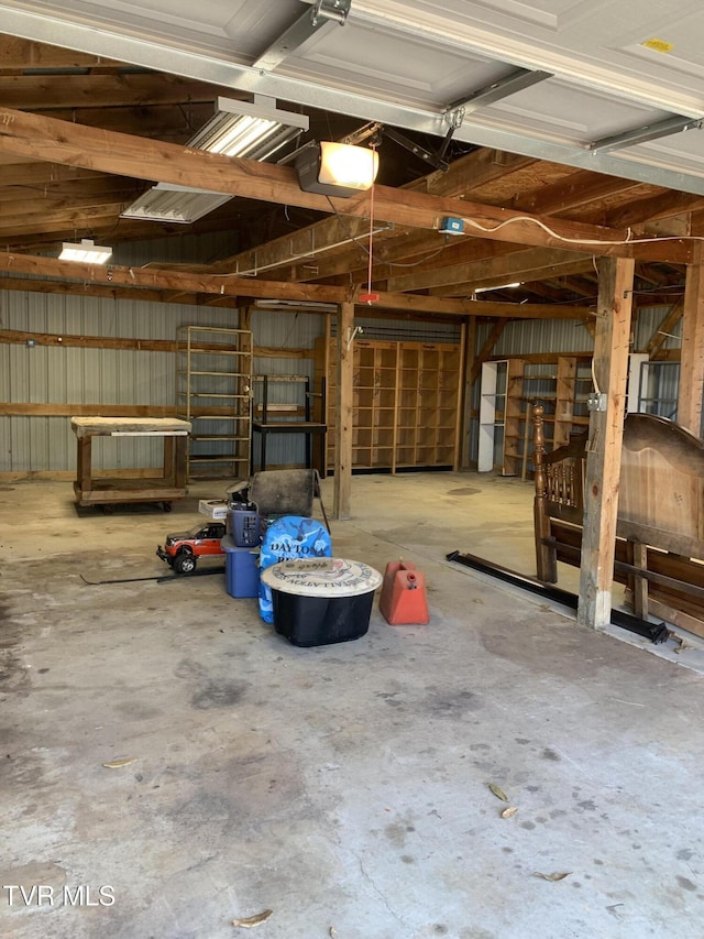 garage featuring a garage door opener and metal wall