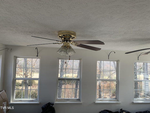 interior details featuring a textured ceiling and ceiling fan