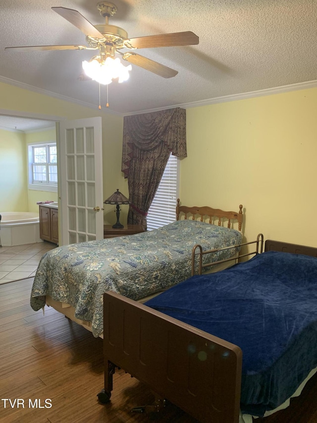 bedroom with ensuite bath, light wood-style flooring, ceiling fan, a textured ceiling, and crown molding