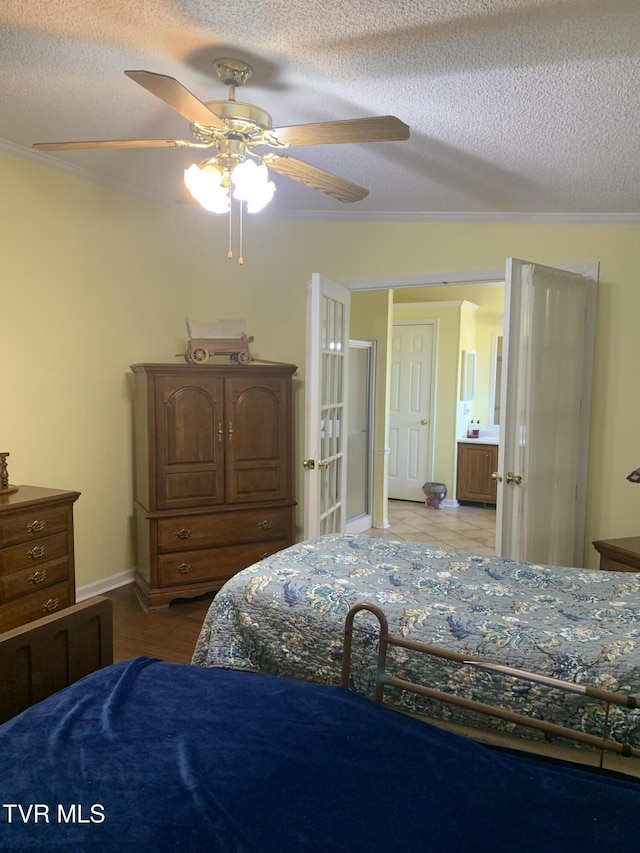 bedroom featuring ceiling fan, baseboards, a textured ceiling, and ornamental molding