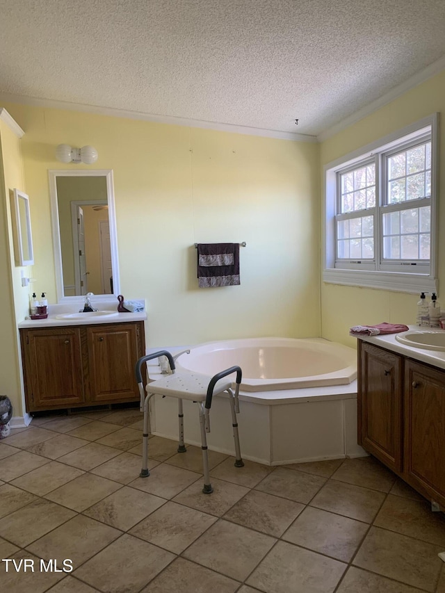 full bath with a textured ceiling, two vanities, a garden tub, and a sink