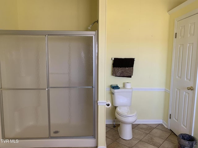 full bathroom with a shower stall, toilet, baseboards, and tile patterned floors