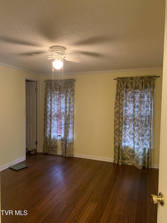 spare room featuring baseboards, crown molding, ceiling fan, and wood finished floors