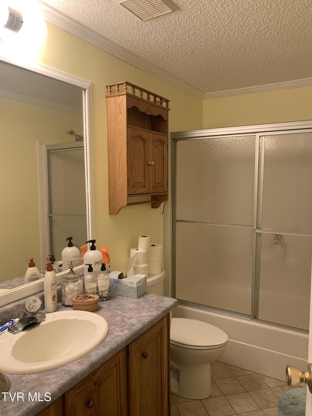 full bathroom featuring tile patterned floors, toilet, a textured ceiling, shower / bath combination with glass door, and vanity