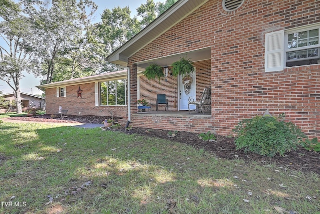 view of side of home with brick siding and a lawn