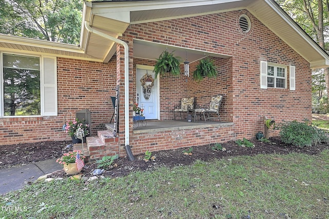 view of exterior entry featuring brick siding