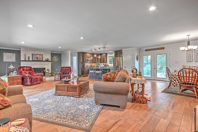 living area featuring french doors, ornamental molding, and light wood finished floors