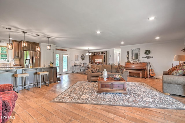 living area featuring recessed lighting, baseboards, plenty of natural light, and light wood-style flooring