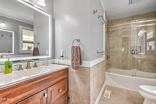 bathroom featuring vanity, tile walls, toilet, and visible vents