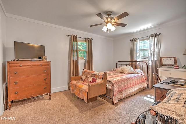 bedroom featuring light colored carpet, baseboards, crown molding, and a ceiling fan