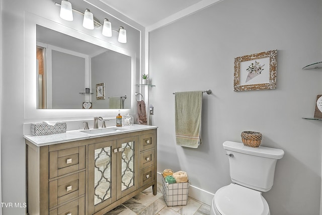 bathroom featuring vanity, toilet, baseboards, and marble finish floor