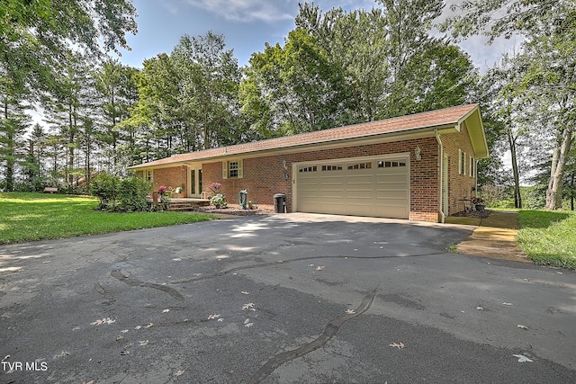 ranch-style house featuring a front lawn, brick siding, an attached garage, and driveway