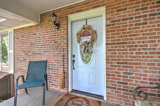 view of exterior entry with brick siding