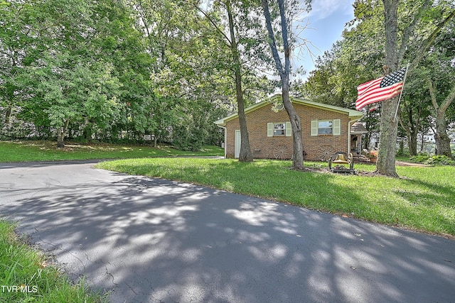 view of property exterior featuring brick siding and a lawn