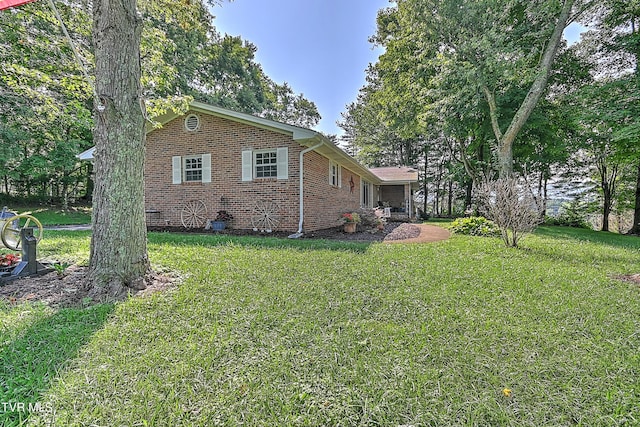 view of side of property featuring a yard and brick siding