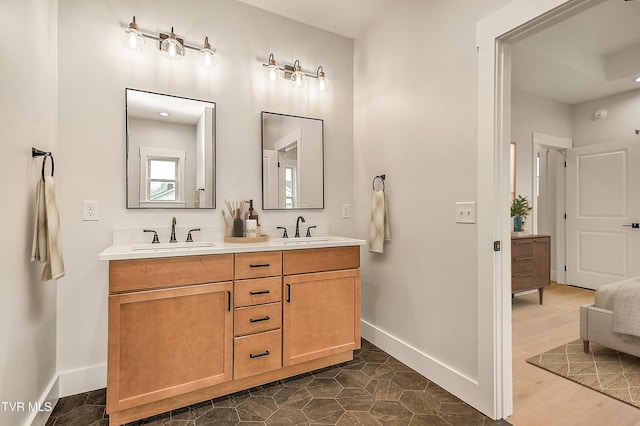 bathroom with a sink, baseboards, and double vanity