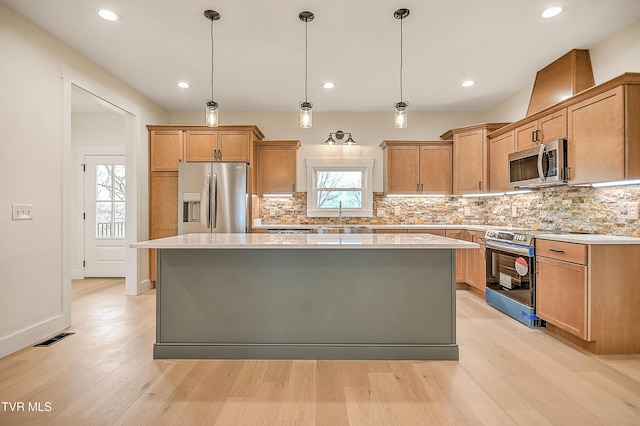 kitchen with visible vents, a sink, light countertops, appliances with stainless steel finishes, and a center island