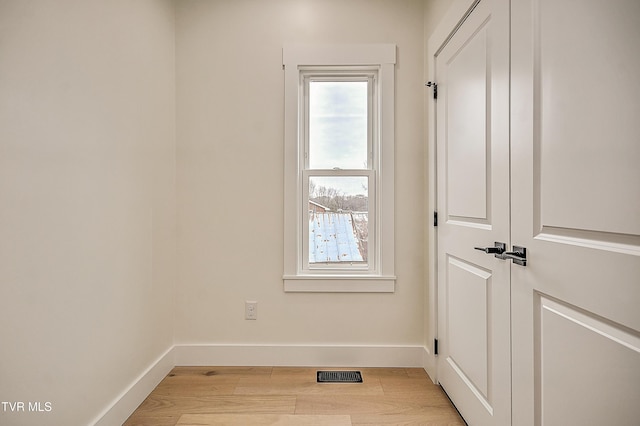 doorway to outside featuring light wood-style floors, visible vents, and baseboards