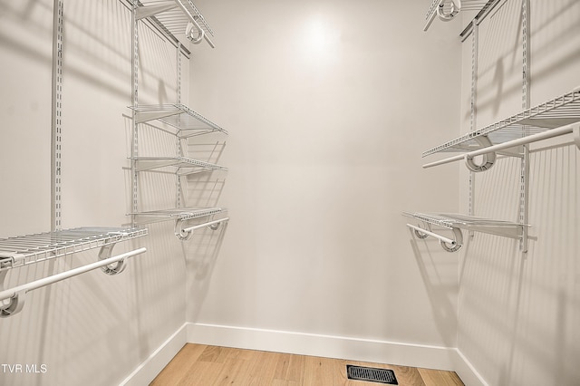 spacious closet featuring light wood-style flooring and visible vents