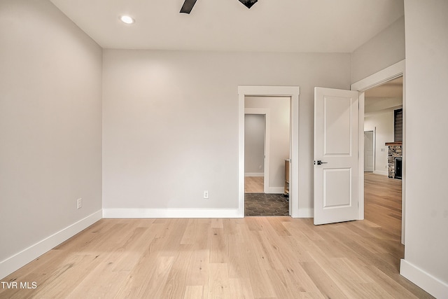 unfurnished room featuring wood finished floors, baseboards, and ceiling fan