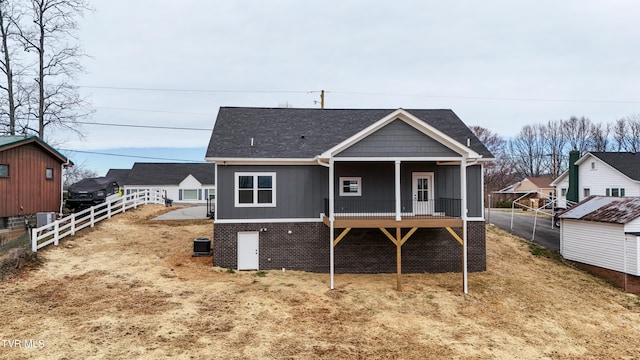 back of property featuring roof with shingles and fence