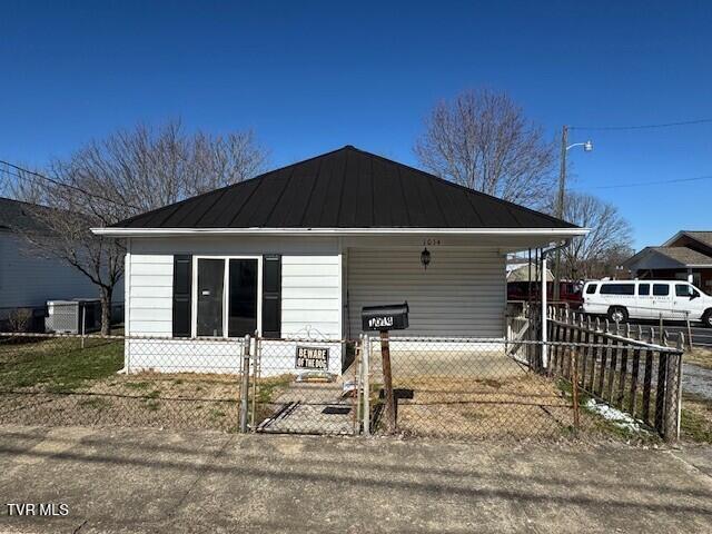 view of side of home featuring a fenced front yard, metal roof, and a standing seam roof