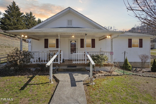 view of front of home with a lawn and a porch