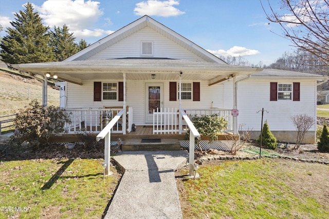 view of front of house featuring covered porch and a front lawn