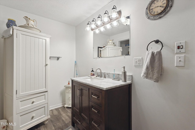 bathroom featuring a textured ceiling, wood finished floors, and vanity