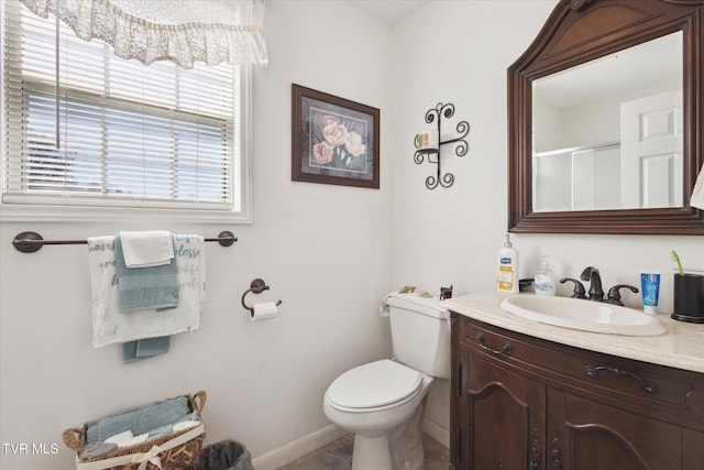 full bathroom featuring a shower with door, toilet, vanity, and baseboards