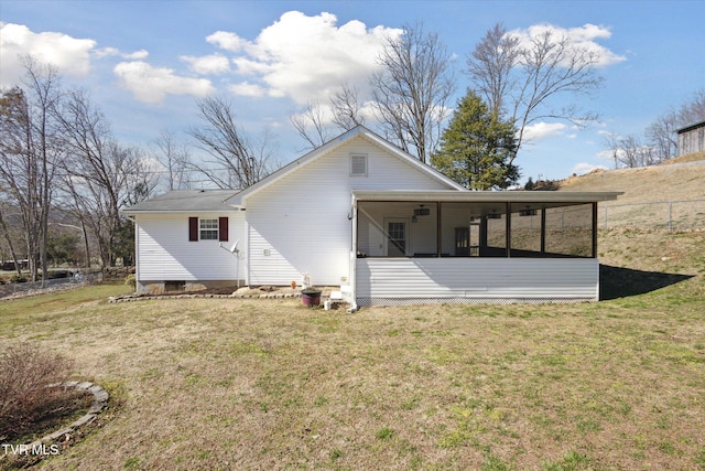 back of property featuring a lawn, fence, and a sunroom