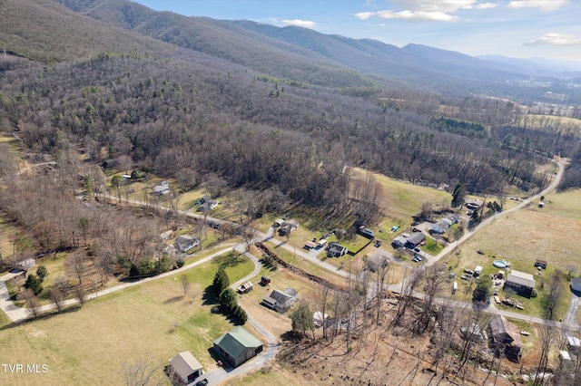 drone / aerial view with a wooded view and a mountain view