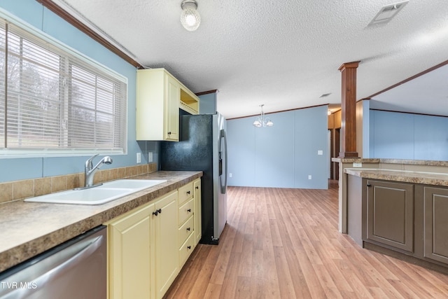 kitchen with light wood finished floors, cream cabinetry, stainless steel appliances, and a sink